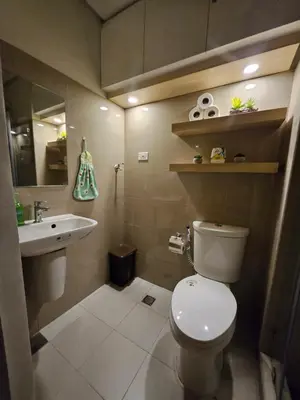 a bathroom with a toilet and a sink at Soleil Suite 10 mins to SM Moa, Pasay - 2 beds in Manila