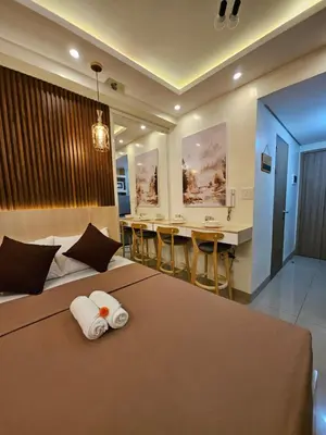 a hotel room with a bed and a table and chairs at Soleil Suite 10 mins to SM Moa, Pasay - 2 beds in Manila