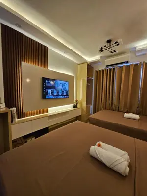 a hotel room with two beds and a flat screen tv at Soleil Suite 10 mins to SM Moa, Pasay - 2 beds in Manila
