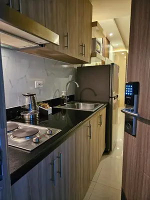 a kitchen with a sink and a refrigerator at Soleil Suite 10 mins to SM Moa, Pasay - 2 beds in Manila