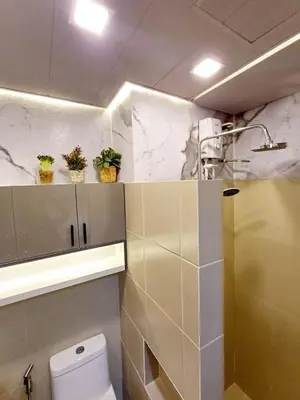 a bathroom with a toilet and plants on the wall at My Staycation moa area S RESIDENCES TOWER 1 in Manila