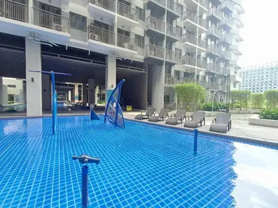 a large swimming pool with chairs and a building at My Staycation moa area S RESIDENCES TOWER 1 in Manila