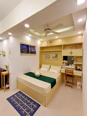 a bedroom with a large bed and a kitchen at My Staycation moa area S RESIDENCES TOWER 1 in Manila