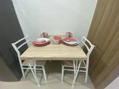 a table with two chairs and plates on it at Shore 2 Residence Tower 3 in Manila