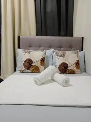 a bed with three pillows and a headboard with at Shore 2 Residence Tower 3 in Manila