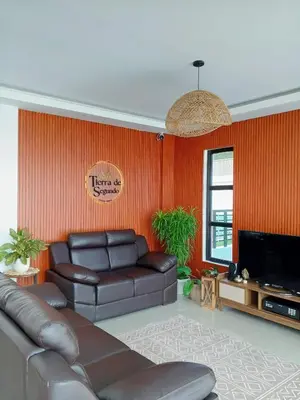 a living room with a leather couch and a television at tierra de segundo in Binangonan