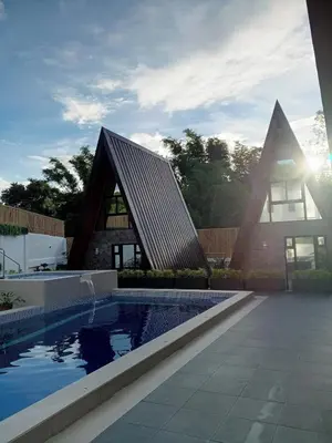 a house with a swimming pool in front of a building at tierra de segundo in Binangonan