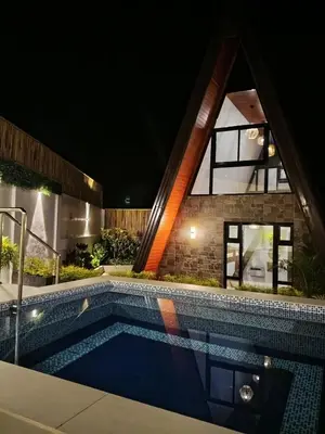a swimming pool in front of a house at night at tierra de segundo in Binangonan