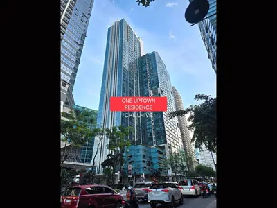 a city street with cars parked in front of tall buildings at 1BR Condo, BGC Uptown Mall, Grand Hyatt #ournw20j in Manila