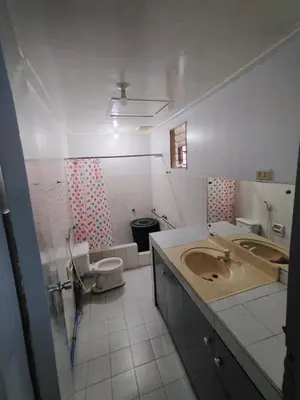 a bathroom with a sink and a toilet at BahayMandaragat in Manila