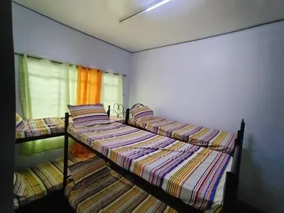 two twin beds in a room with a window at BahayMandaragat in Manila