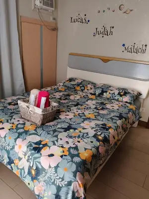 a bed with a floral bedspread and baskets on it at LDN Secret 1BR across NAIA Terminal 3 in Manila