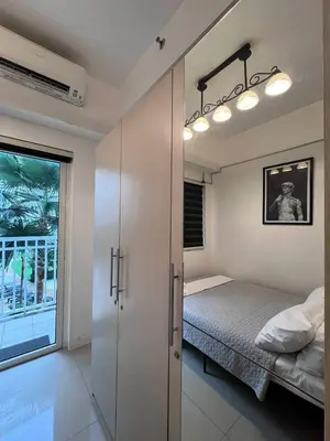 a bedroom with a bed and a sliding glass door at Biglaang Lakad by Metro Staycation in Manila