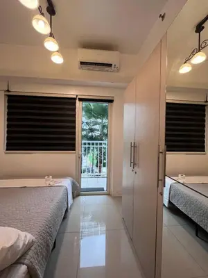 a bedroom with two beds and a sliding glass door at Biglaang Lakad by Metro Staycation in Manila