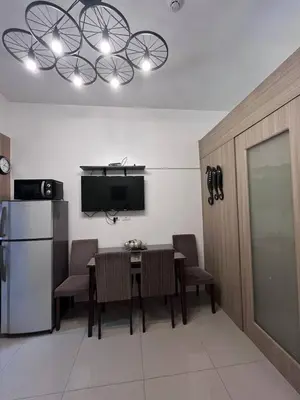 a kitchen with a table with chairs and a refrigerator at Biglaang Lakad by Metro Staycation in Manila