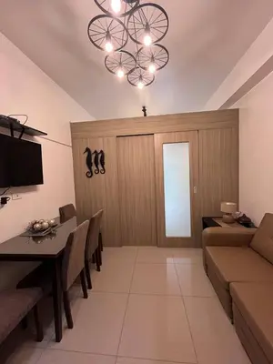 a living room with a couch and a table and a chandelier at Biglaang Lakad by Metro Staycation in Manila