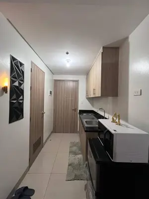 a kitchen with a sink and a microwave at Biglaang Lakad by Metro Staycation in Manila