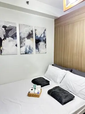 a bedroom with a bed with two towels on it at Wander & Chill Staycation in Manila