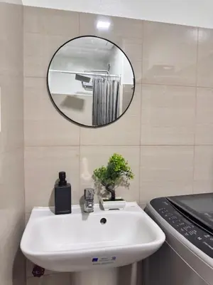 a bathroom with a white sink and a mirror at Wander & Chill Staycation in Manila