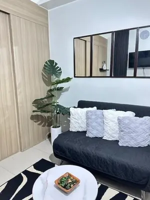 a living room with a couch and a table at Wander & Chill Staycation in Manila