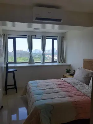 a bedroom with a large bed and a window at Barkada Pamilya BnB by Metro Staycation in Manila