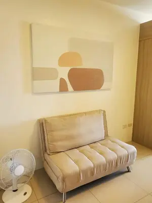 a living room with a couch and a fan at Barkada Pamilya BnB by Metro Staycation in Manila