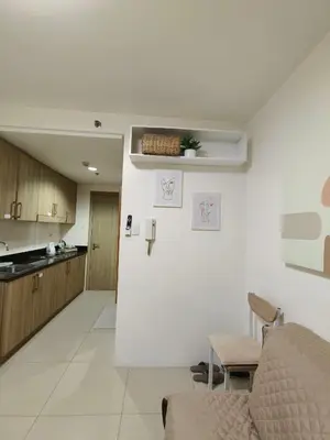a kitchen and a living room with a couch and a table at Barkada Pamilya BnB by Metro Staycation in Manila