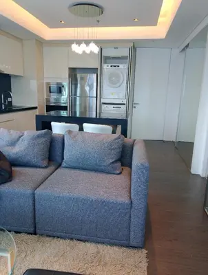 a living room with a couch and a kitchen at Alphaland Suites Apartment Hotel in Manila