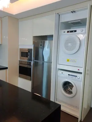 a kitchen with a refrigerator and a washer and dryer at Alphaland Suites Apartment Hotel in Manila