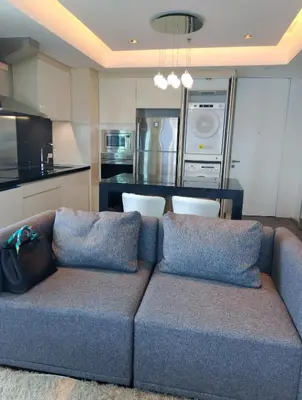 a living room with a couch and a kitchen at Alphaland Suites Apartment Hotel in Manila