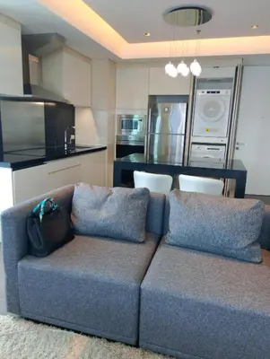 a living room with a couch and a kitchen at Alphaland Suites Apartment Hotel in Manila