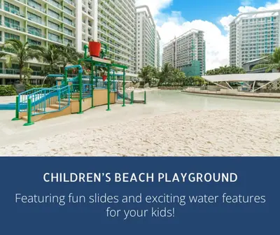 a playground on a beach with buildings in the background at Azure Resort Residence, 1bedroom with balcony Beach view in Manila