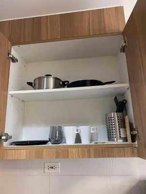 a kitchen cabinet with a pot and other kitchen utensils at Comfort Cove at Shore 3 in Manila