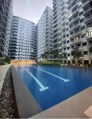 a large swimming pool in front of two tall buildings at Comfort Cove at Shore 3 in Manila