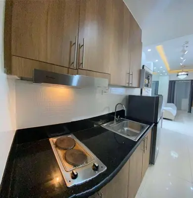 a kitchen with a sink and a stove top oven at Comfort Cove at Shore 3 in Manila