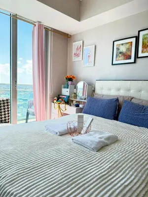 a bedroom with a bed with a view of the ocean at Isla Cabana Azure Staycation in Manila