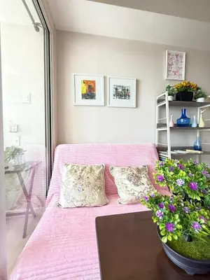 a living room with a pink couch and flowers at Isla Cabana Azure Staycation in Manila