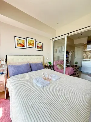a bedroom with a large white bed with a mirror at Isla Cabana Azure Staycation in Manila