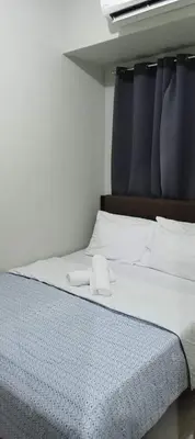 a bed with two white towels on top of it at One Bedroom Apartment near MOA in Manila