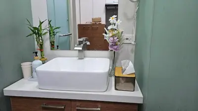 a bathroom sink with a vase of flowers on it at Chic Studio near Megamall and Shangrila Plaza in Manila