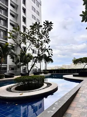 a tree in a pool in front of a building at Shore 2 Residence in Manila