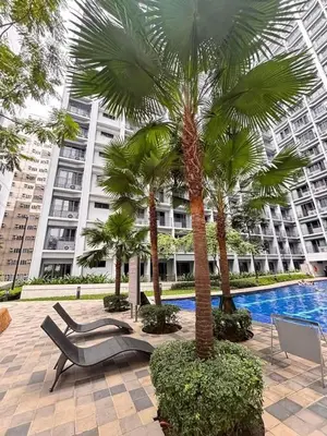 a resort with palm trees and a swimming pool at Shore 2 Residence in Manila
