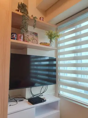 a living room with a flat screen tv and a window at Pixie Dust Suite in Manila