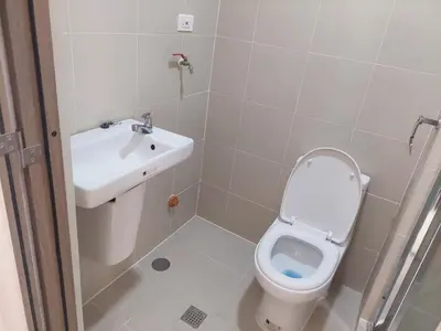 a small bathroom with a toilet and a sink at FAME Bedroom in Manila