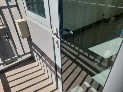 a glass door with a table on a balcony at FAME Bedroom in Manila