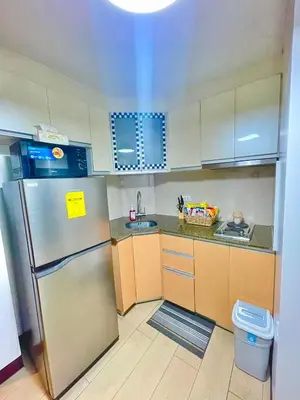 a small kitchen with a stainless steel refrigerator at ASD Airport Condotel Pasay in Manila