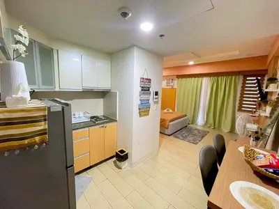 a kitchen with a refrigerator and a dining room at ASD Airport Condotel Pasay in Manila