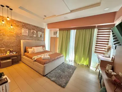 a bedroom with a bed and a brick wall at ASD Airport Condotel Pasay in Manila