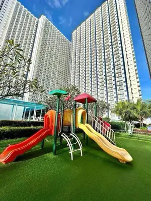 a playground with slides in front of a large building at Jazz Residences Makati Tower B in Manila