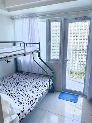 a bunk bed in a room with two windows at Jazz Residences Makati Tower B in Manila